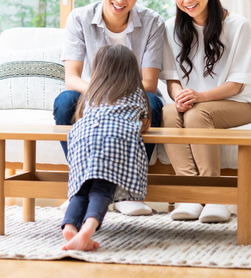 机に前のめりになって両親を見つめる子どもの様子