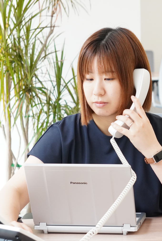 真剣な表情で電話対応をする女性