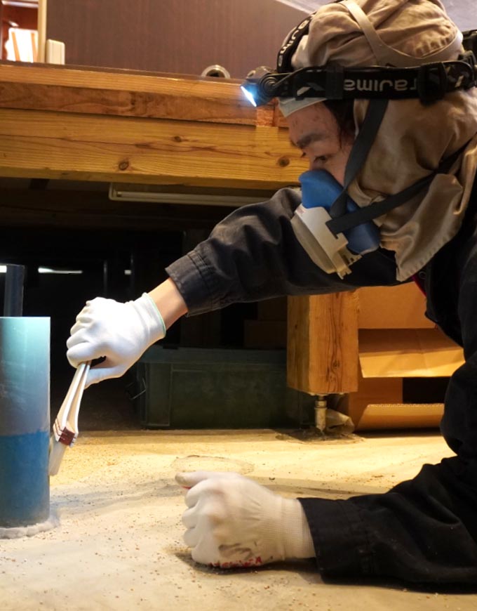 床下で配管施工を行う職人